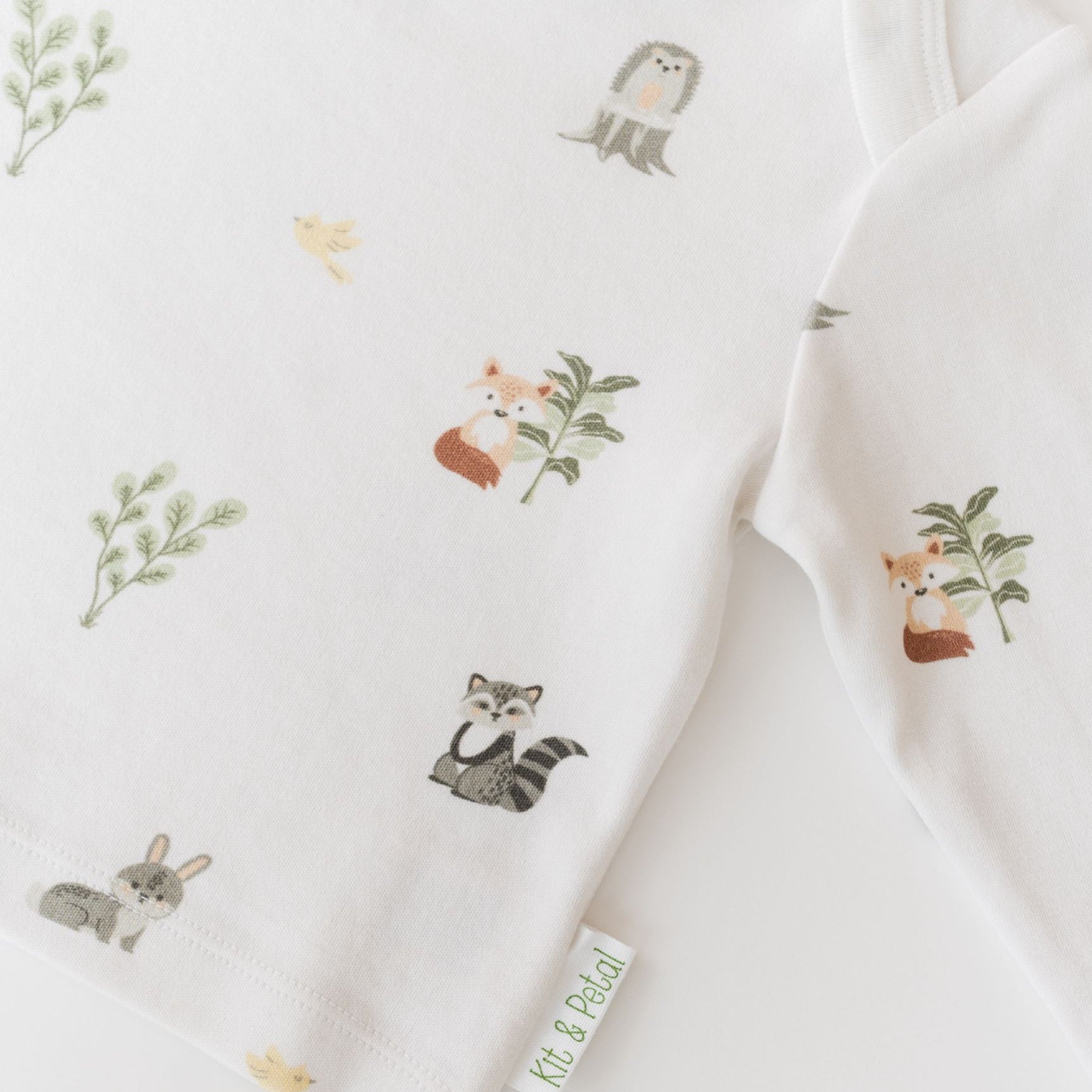 Close-up of Kit & Petal brand tag on Forest Friends organic cotton baby long sleeve shirt