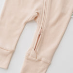 Zoomed-in view of the double zipper for easy dressing on the Rosy Peach long sleeve romper.