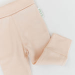 Close-up of Rosy Peach organic cotton baby pants with fold-over waistband and wide, soft cuffs for comfort.