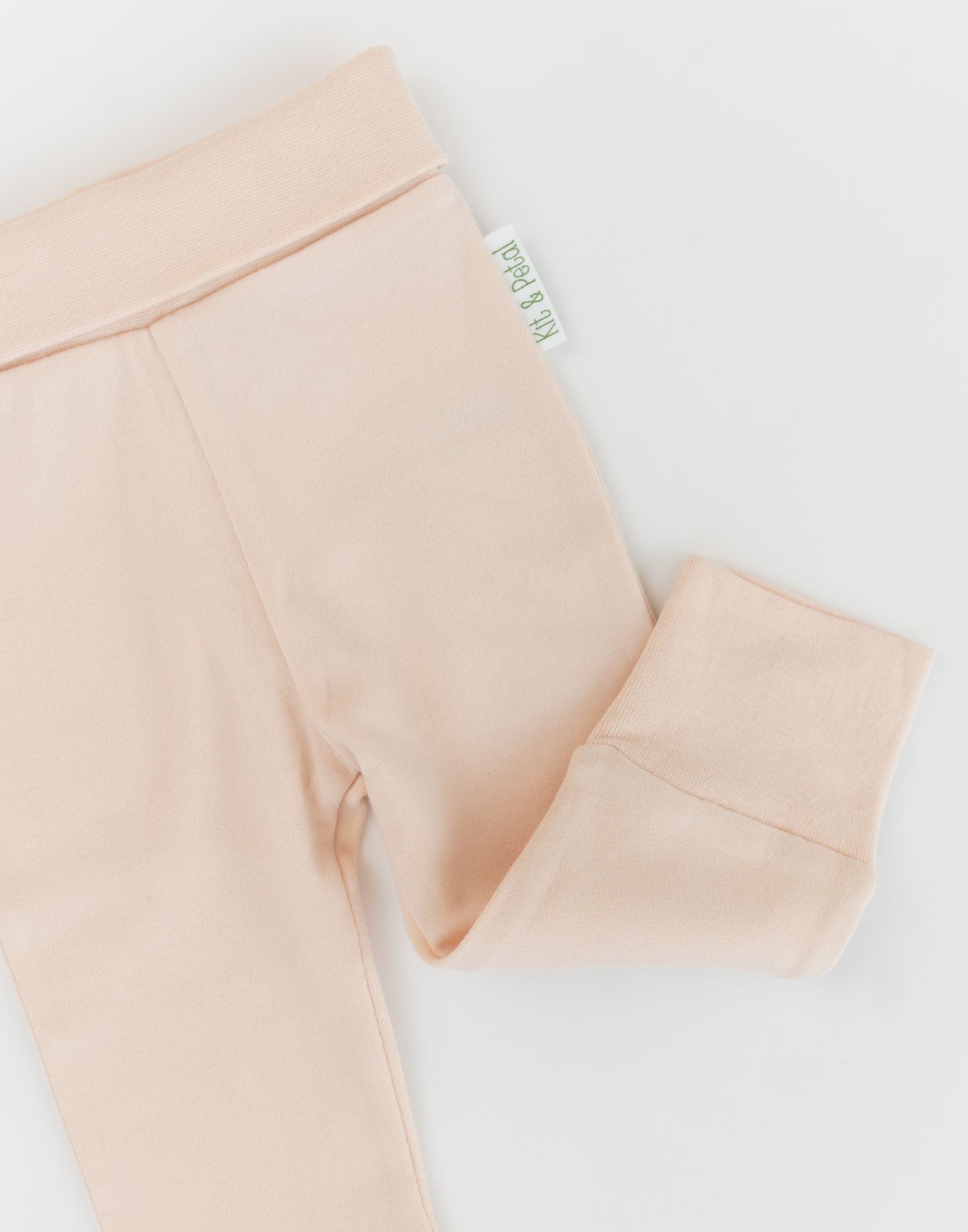 Close-up of Rosy Peach organic cotton baby pants with fold-over waistband and wide, soft cuffs for comfort.