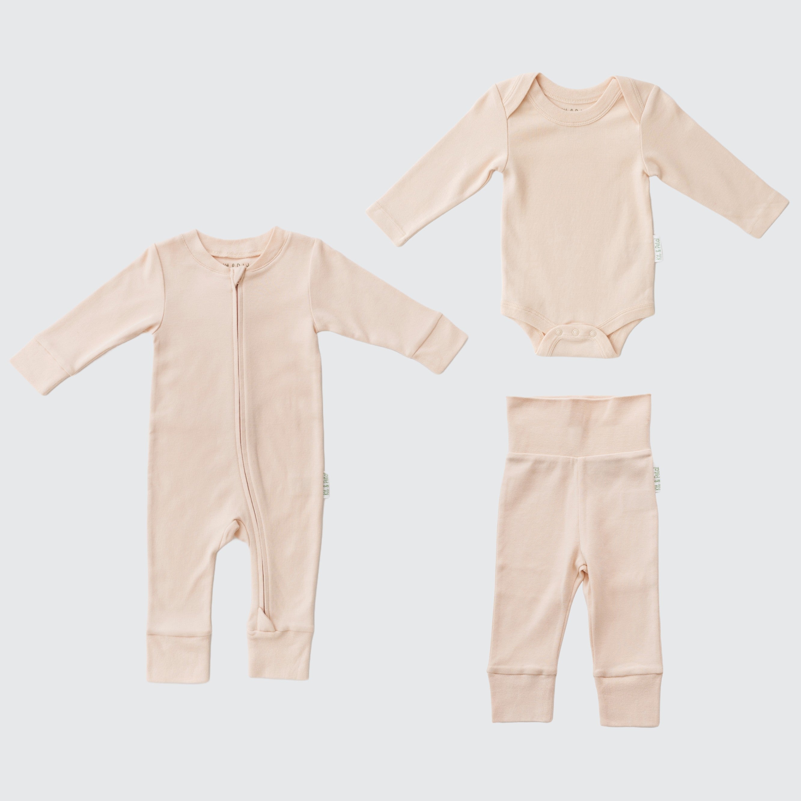 Flat lay of a long sleeve rosy peach romper, rosy peach long sleeve bodysuit and rosy peach fold-over pants.