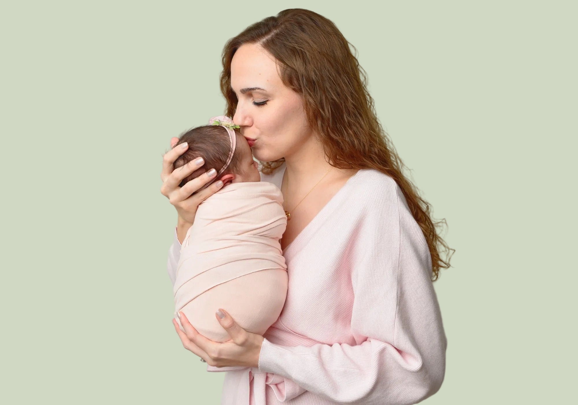 Founder of Kit & Petal holding her baby daughter with a green background