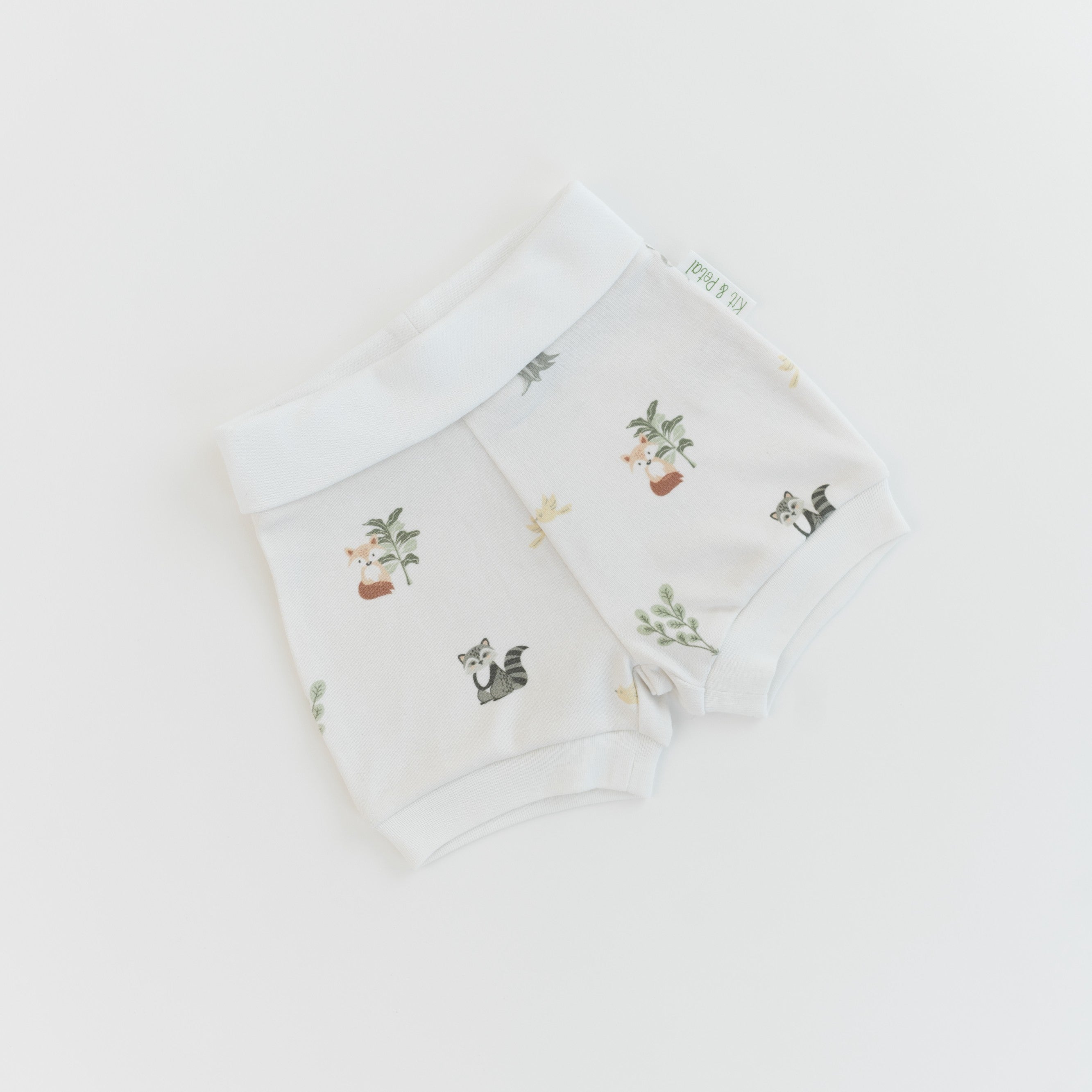 Organic cotton baby fold-over shorts in forest friends animal print, with the waistband folded down
