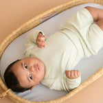 Baby wearing leafy green organic cotton long sleeve bodysuit and fold-over shorts