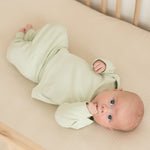 Baby wearing leafy green organic cotton fold-over pants and matching long sleeve shirt