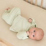 Baby wearing leafy green organic cotton fold-over pants and matching long sleeve shirt