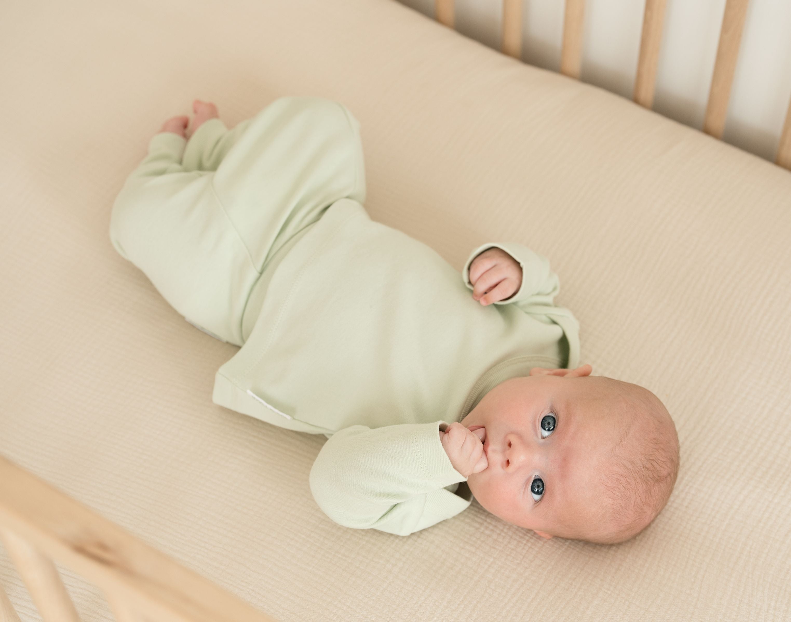 Baby wearing leafy green organic cotton fold-over pants and matching long sleeve shirt