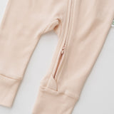 Close-up of double zipper on rosy peach organic cotton baby long sleeve romper