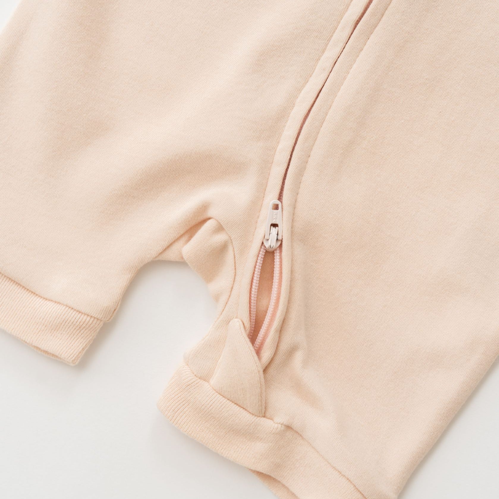 Close-up of double zipper on Rosy Peach organic cotton baby short sleeve romper.