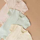 Three short sleeve rompers in all three colorways including peach, green and yellow