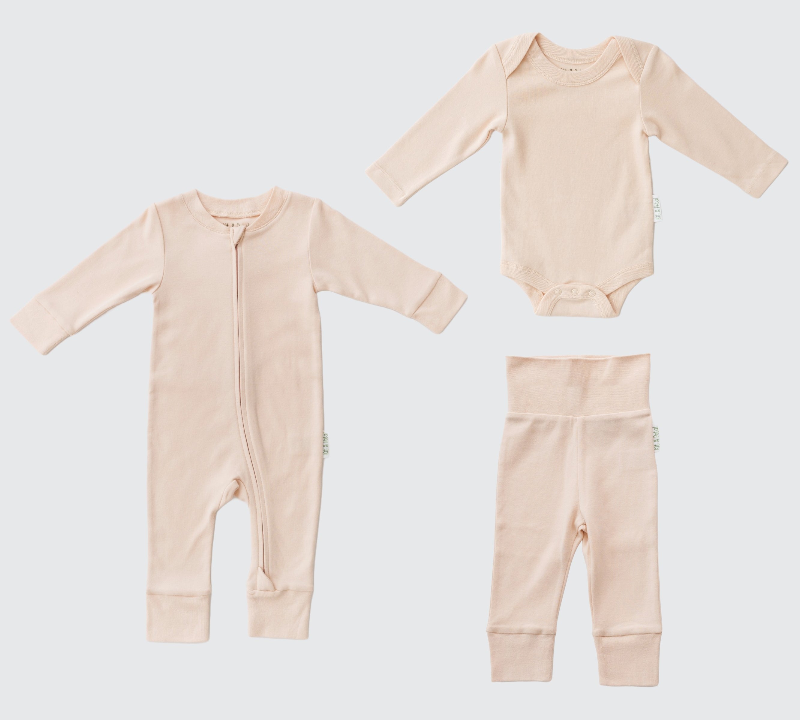 Flat lay of a long sleeve rosy peach romper, rosy peach long sleeve bodysuit and rosy peach fold-over pants.