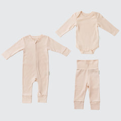 Flat lay of a long sleeve rosy peach romper, rosy peach long sleeve bodysuit and rosy peach fold-over pants.