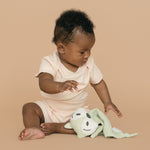 Baby wearing a Rosy Peach organic cotton short sleeve bodysuit and fold-over shorts, playing with a fox toy.